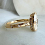 Direct side profile view of a celestial star-set yellow gold band featuring a 5 CT oval lab diamond with hidden undergallery halo.