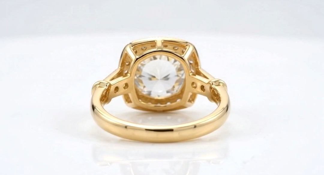 Undergallery bottom view of a 4 CT round lab grown diamond engagement ring in yellow gold showing the open basket frame and shoulder accents.
