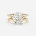 Front view of a 4 CT oval cut lab grown diamond engagement ring with a dual pavé and plain gold double band.