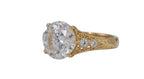 Side undergallery perspective showing high-polish yellow gold band transitioning to hand-engraved floral motifs.