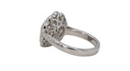 Side view of a 2 CT round lab grown diamond ring displaying an openwork scalloped gallery and engraved leaf shoulders in white gold.