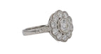 Angled perspective of a white gold 2 CT round lab diamond ring showing the floral bloom setting and hand-engraved band accents.