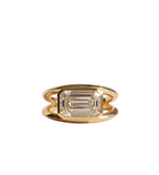 Top-down view of a 3 CT emerald cut lab grown diamond mounted horizontally in a polished yellow gold bezel with a split double band.