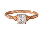 Front view of a 2 carat cushion cut lab diamond set in a rose gold vintage nature-inspired ring with carved leaf motifs.