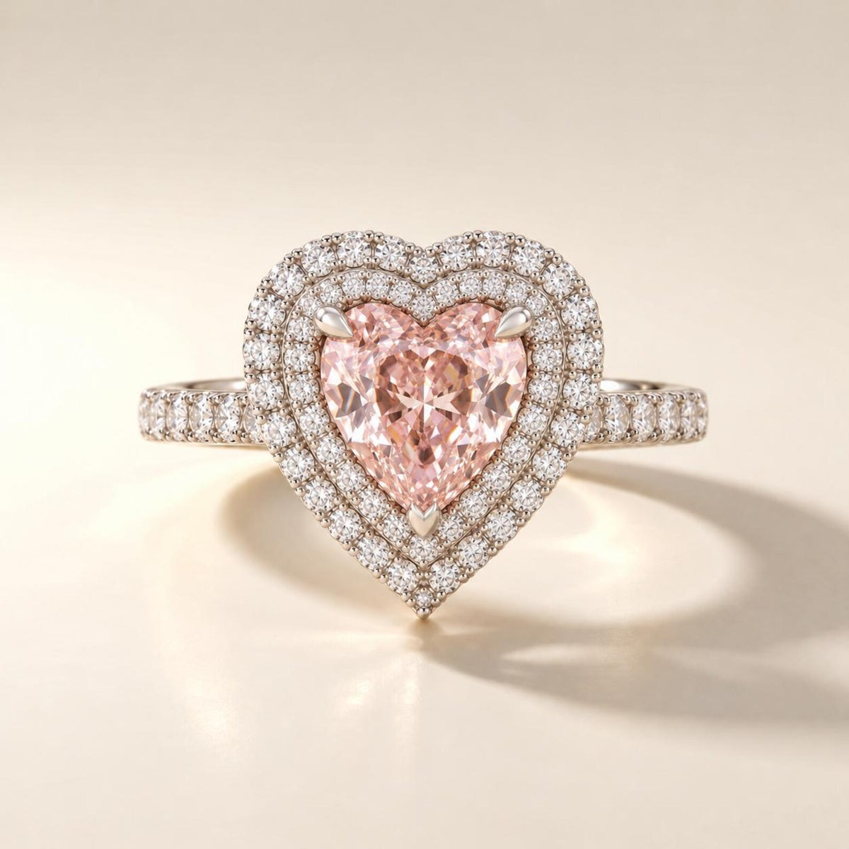 Frontal face-up view of a 2 CT pink heart cut lab grown diamond engagement ring surrounded by a sparkling double diamond halo.