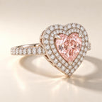 Angle view showcasing the double halo setting and pavé-set diamond band holding a 2 carat heart cut fancy pink lab diamond.