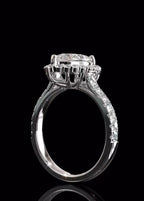 Side profile of a 3 CT pear cut lab grown diamond engagement ring highlighting the elevated crown basket setting and delicate pave band against a dark background.