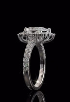 Angled side profile showing the structural raised gallery beneath the scalloped halo of a white gold pear cut diamond ring.