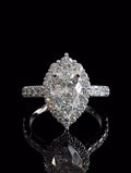 High-angle top view of a stunning 3 carat pear shaped lab diamond ring featuring a vintage-inspired scalloped diamond halo.