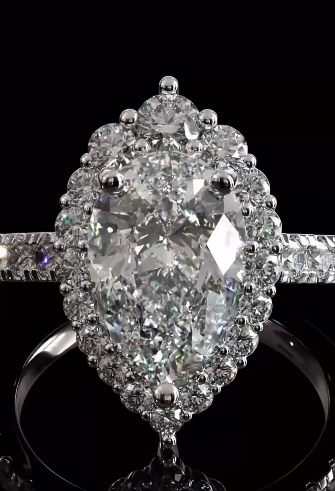 Direct top-down macro shot capturing the perfect symmetry, brilliant fire, and floral halo design of the 3 CT pear cut engagement ring.