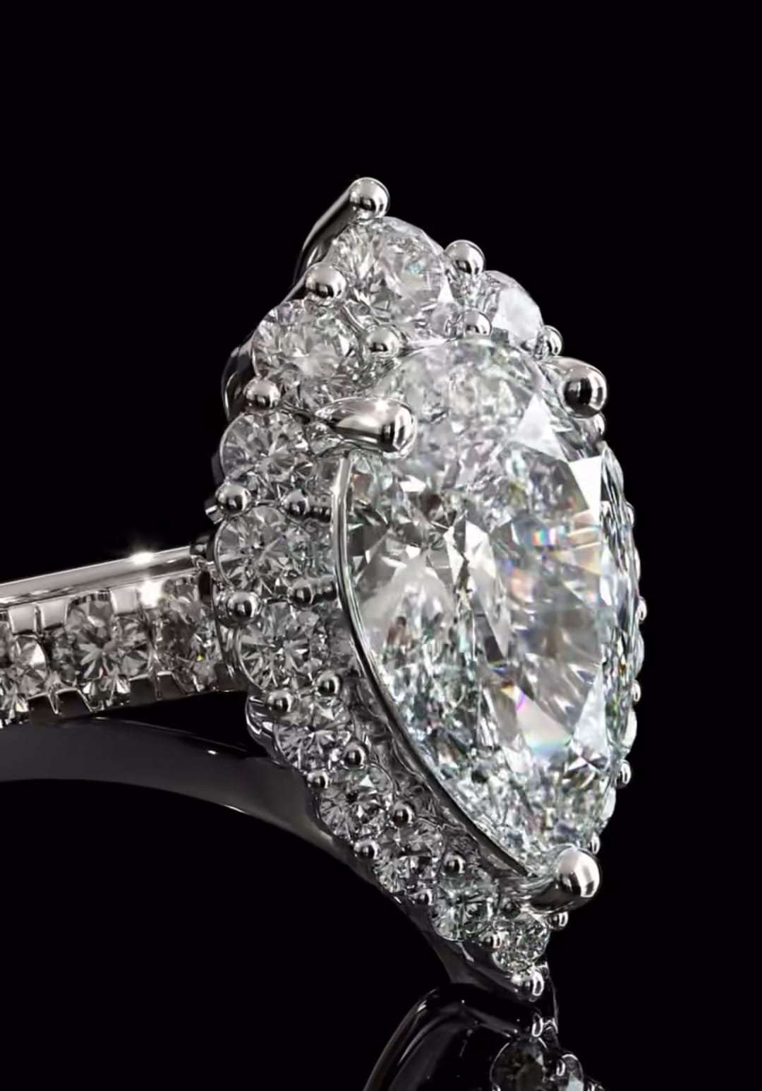 Extreme close-up angled profile highlighting the secure prong setting, the scalloped halo border, and the deep brilliance of the pear diamond.