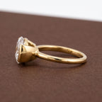 Side profile angle of yellow gold East-West pear lab diamond solitaire ring showing open basket gallery.