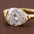 Extreme close-up macro view of a 2 CT pear cut lab grown diamond facet brilliance held in a half-bezel frame.