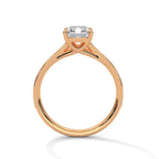 Direct side profile view of a rose gold 4 carat emerald cut lab diamond ring showing cathedral bridge setting.