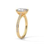 Angled perspective view of a 4 CT emerald cut lab diamond engagement ring in yellow gold with micro-pavé band.