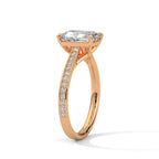 Perspective view of a rose gold 4 CT emerald cut lab diamond ring highlighting sparkling pave diamond shank.