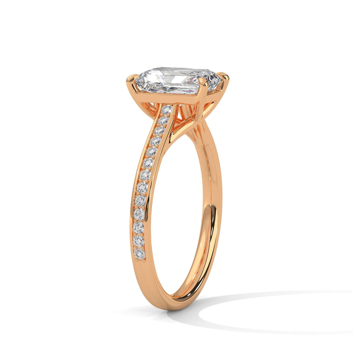 Perspective view of a rose gold 4 CT emerald cut lab diamond ring highlighting sparkling pave diamond shank.