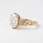 Side profile perspective of a yellow gold 3 CT oval lab diamond ring showcasing detailed vine scrollwork and leaf motif.