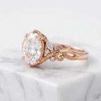 Side profile perspective of a rose gold 3 CT oval cut lab diamond engagement ring with intricate botanical band carving.