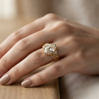 Close-up lifestyle photo of a 3 carat oval lab grown diamond ring in yellow gold worn on finger.
