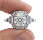 Close-up of fingers holding an Art Deco 3 carat cushion cut lab grown diamond halo ring, highlighting the intricate milgrain and geometric design.