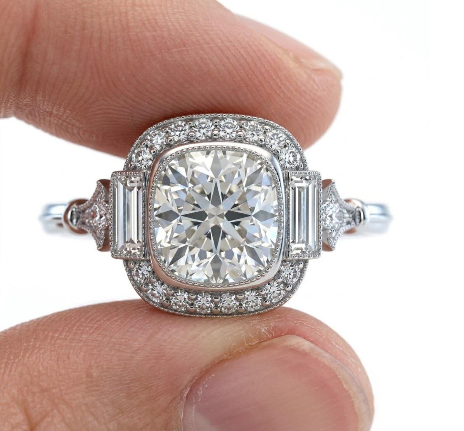Close-up of fingers holding an Art Deco 3 carat cushion cut lab grown diamond halo ring, highlighting the intricate milgrain and geometric design.