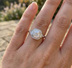 Woman's hand wearing a stunning vintage-style 3 CT cushion cut lab grown diamond engagement ring with baguette side stones in natural outdoor lighting.