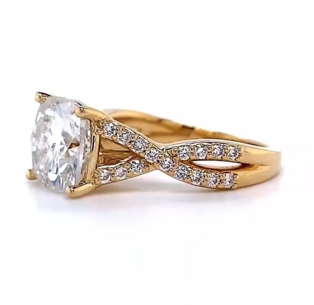 Angled side profile highlighting the diamond-encrusted crossing split band and the secure four-prong setting of the brilliant cushion cut center stone.