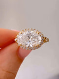 Close-up top view of a 3 CT oval cut lab grown diamond set horizontally in an East-West yellow gold halo ring.