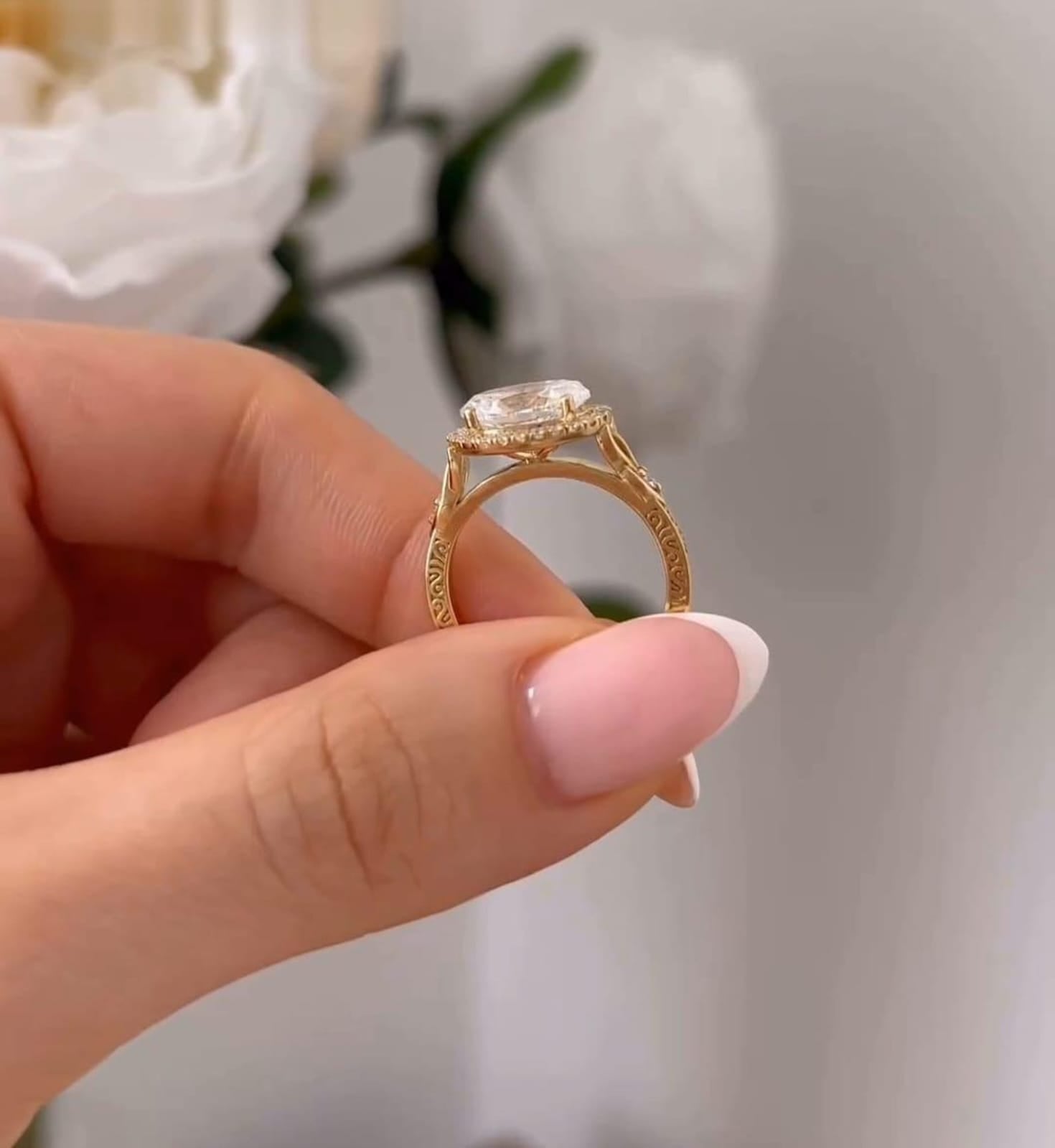Side profile shot showing the raised halo setting and intricate engraved details along the yellow gold shank.