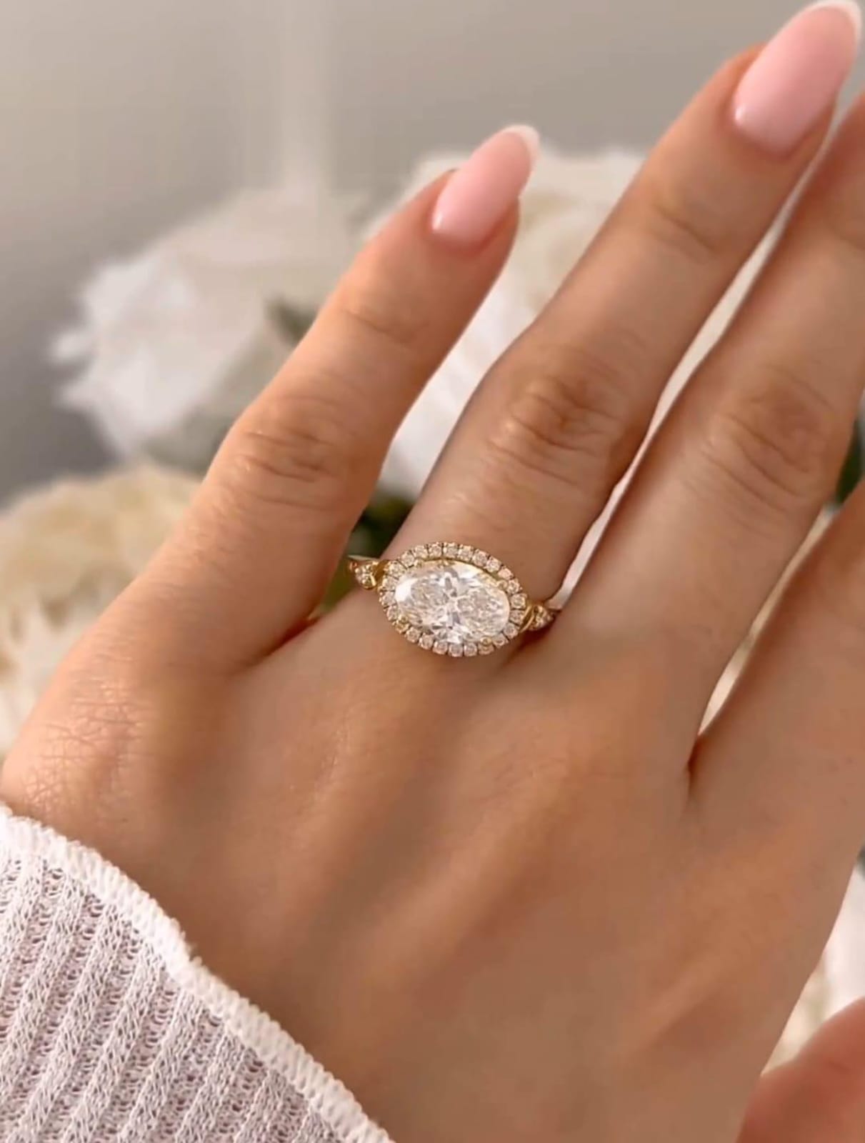 On-finger view showing how the 3 CT East-West oval halo diamond ring sits gracefully on the hand.