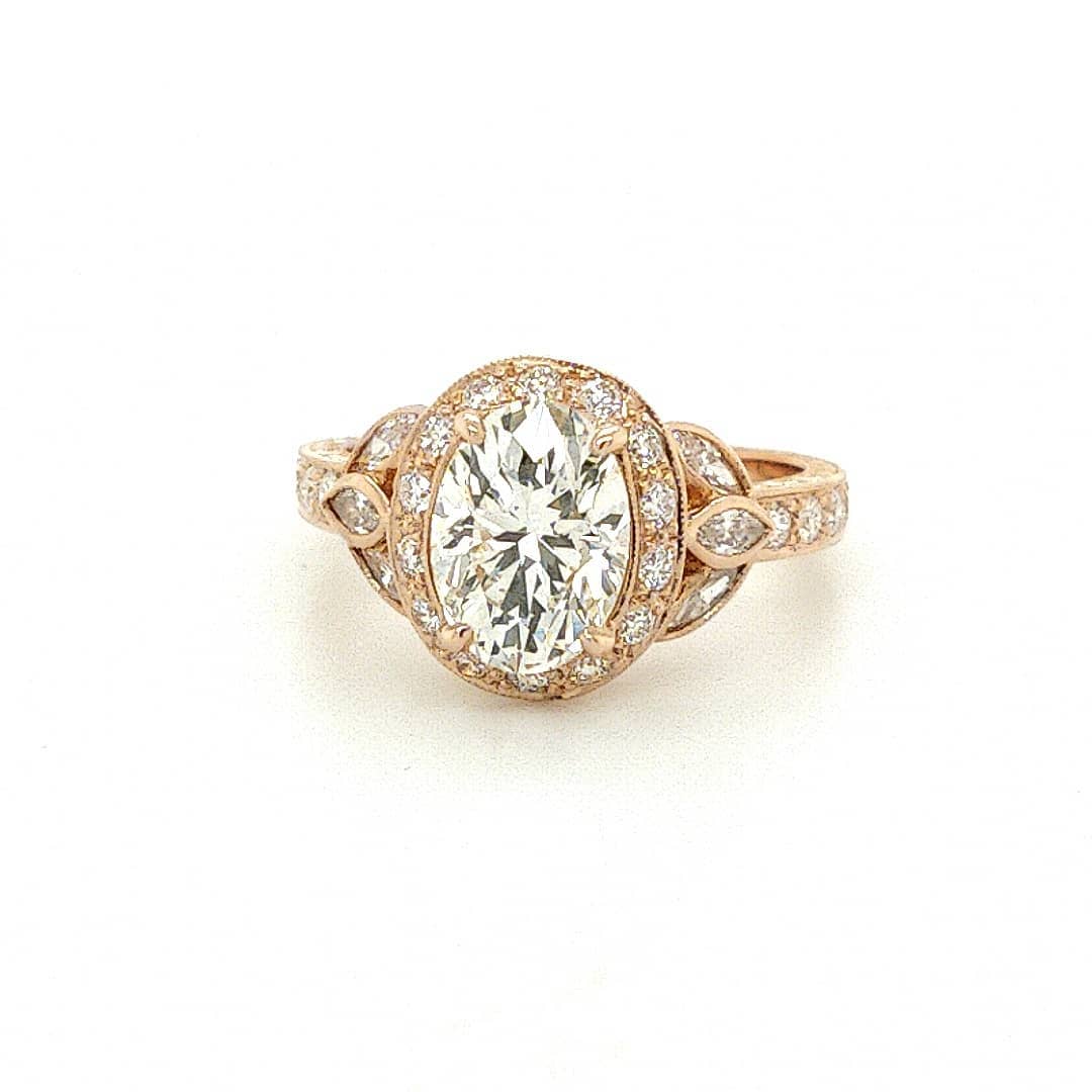 Front view of a 3 CT oval cut lab grown diamond featuring a rose gold halo setting and marquise side accents