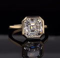 Front view of a 4 CT Asscher cut lab grown diamond set in a modern yellow gold bezel frame