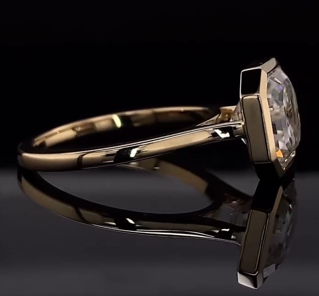 Side profile view showing the sleek bezel basket and plain yellow gold band of the Asscher diamond ring