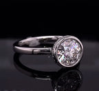 Angled view showing the brilliant round cut lab diamond framed in a sleek white gold bezel