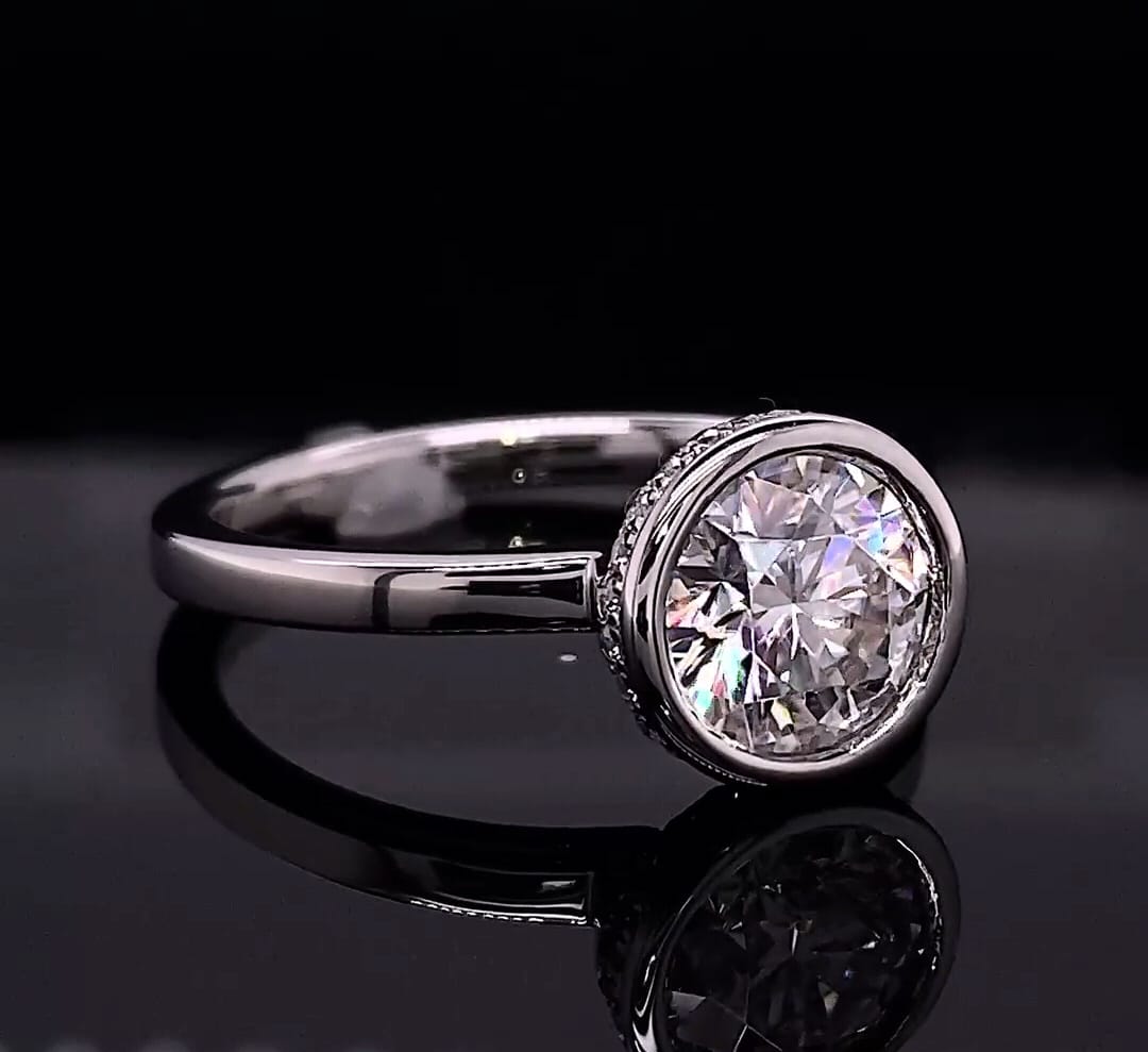 Angled view showing the brilliant round cut lab diamond framed in a sleek white gold bezel