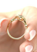 Side profile view showing the slender yellow gold band and raised halo basket setting