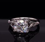 Front view of a 3 CT cushion cut lab grown diamond in a white gold botanical leaf setting