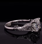 Detailed profile view highlighting the hand-sculpted leaf motif on the setting of a cushion cut diamond ring