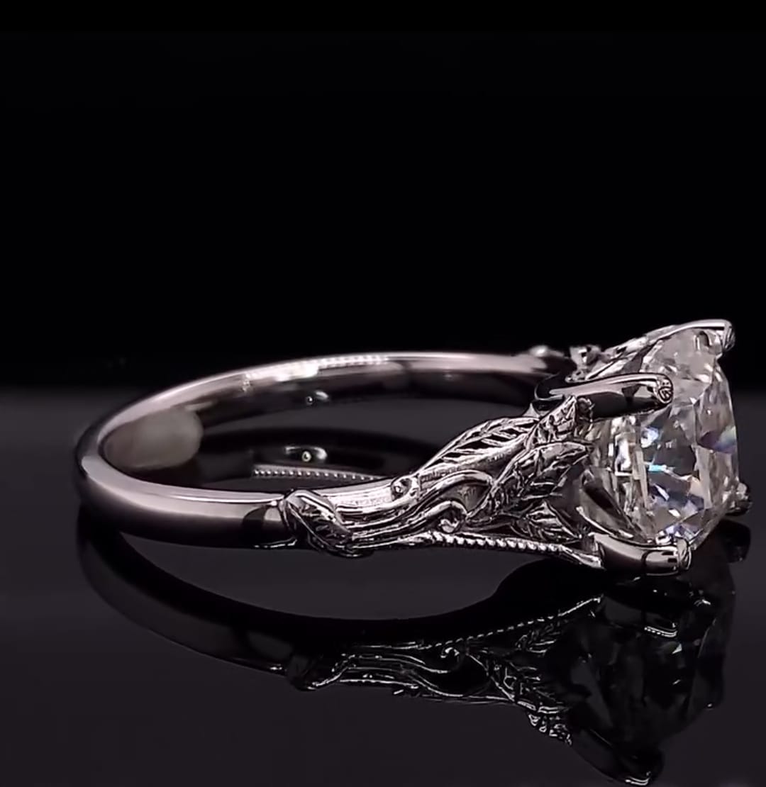 Detailed profile view highlighting the hand-sculpted leaf motif on the setting of a cushion cut diamond ring
