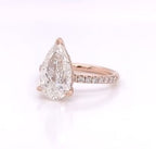 Three-quarter view of a 4 CT pear cut lab grown diamond ring with pavé band in rose gold