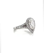 Three-quarter view of a 3 CT pear cut lab grown diamond halo ring with split-shank pavé band in white gold