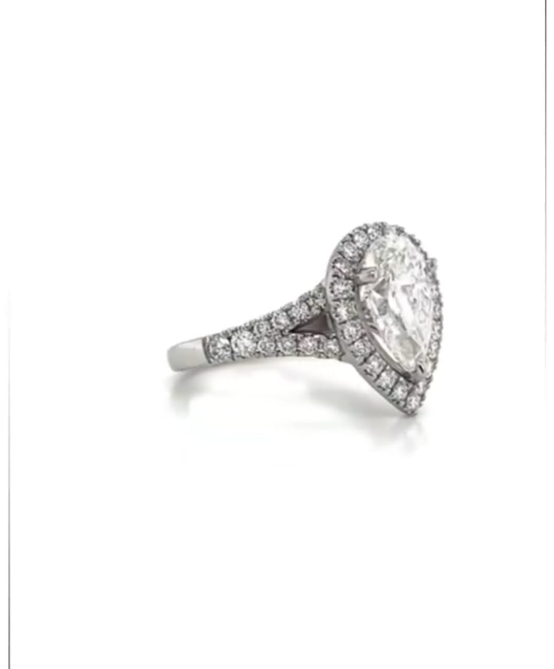 Three-quarter view of a 3 CT pear cut lab grown diamond halo ring with split-shank pavé band in white gold