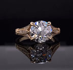 Front view showing a 3 CT round brilliant lab diamond in a double prong setting with decorated yellow gold shoulders