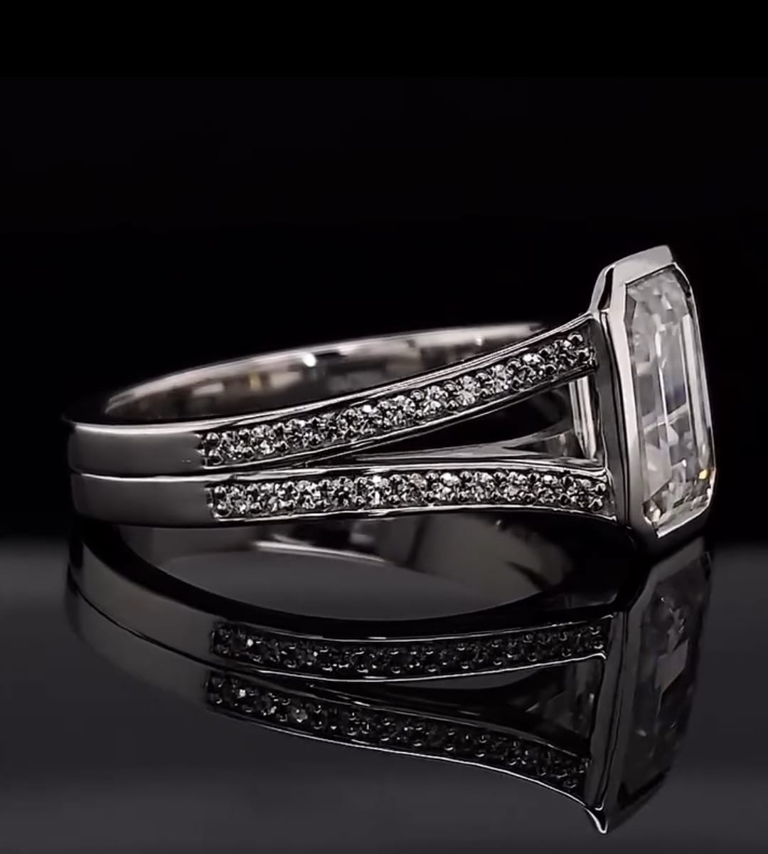 Detailed side profile highlight of the smooth white gold bezel frame enclosing a 4 carat emerald cut lab diamond.