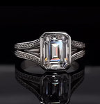 Direct top-down view showing step-cut facets of a 4 CT lab diamond enclosed in a protective bezel setting.