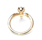 A gold ring with a unique band design and a decorative top, shown on a plain white background.