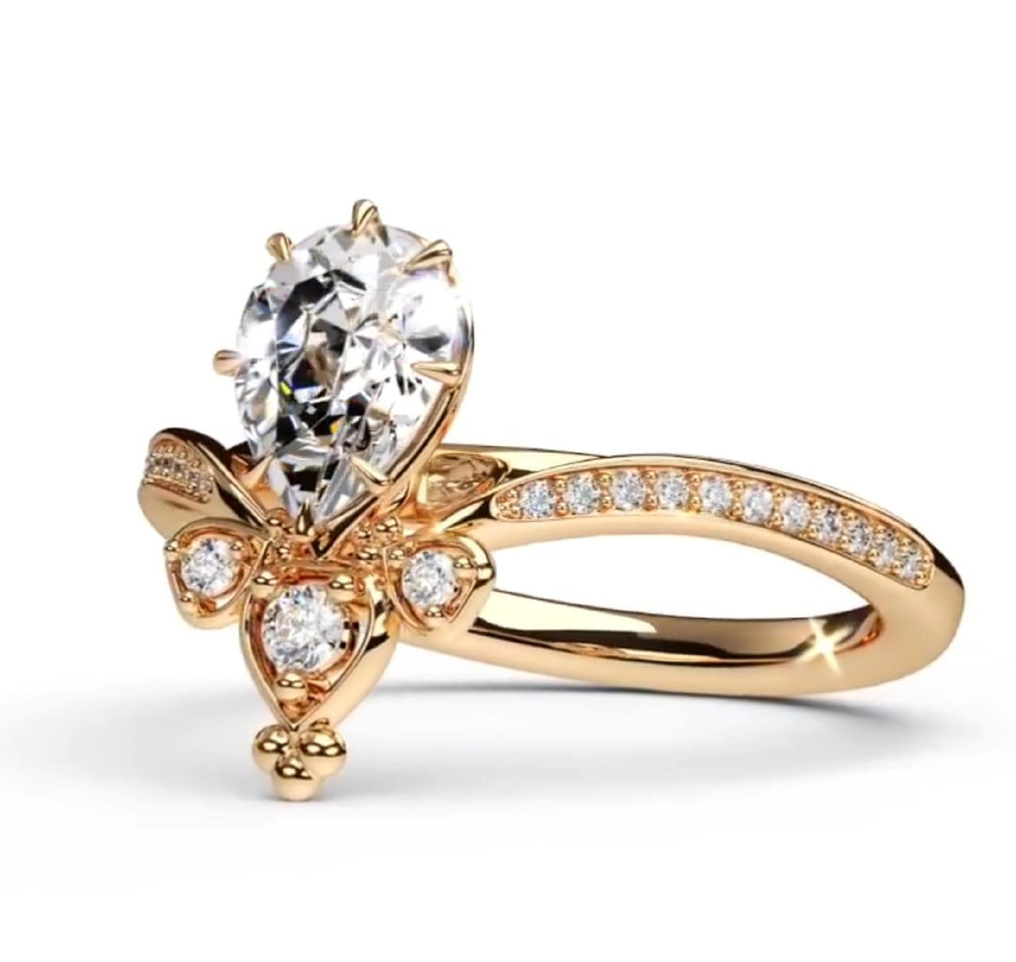 A rose gold engagement ring featuring a pear-cut center diamond and smaller round diamonds, set on a polished band with pavé diamonds
